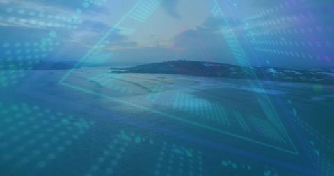 Futuristic digital triangle overlay on coastal seascape at dusk