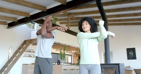 Couple Performing Morning Stretches in Cozy Living Room