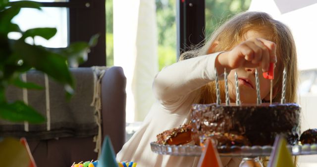 Cute girl decorating cake at home. Girl sticking stick on cake 4k