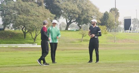 Athletes Discussing Strategy on Cricket Field Outdoors