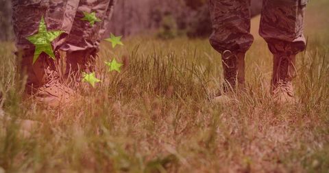 Soldiers standing in camouflage boots on grassy field training with five-star overlay