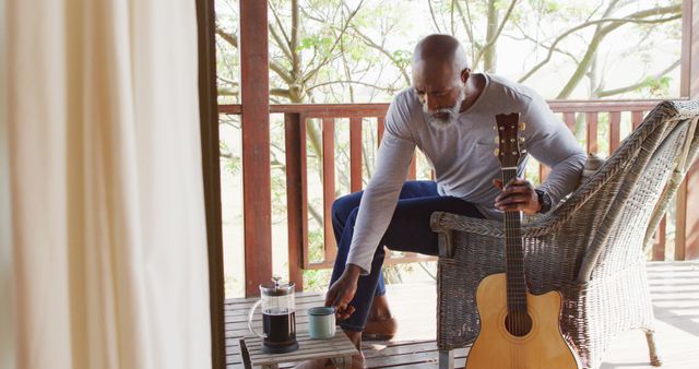 Man Relaxing on Porch with Coffee and Acoustic Guitar - Download Free Stock Images Pikwizard.com