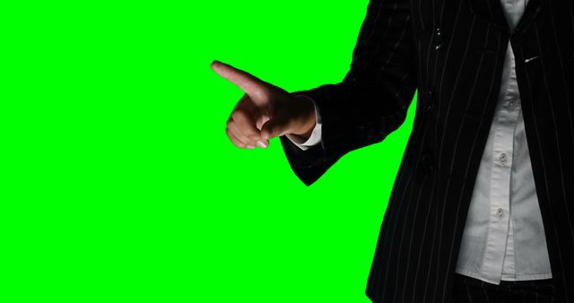 Ideal for presentations, educational materials, and marketing, this image showcases a business professional making a pointing gesture against a green screen background. Perfect for business presentations, adding to instructional videos, or creating digitally altered images.