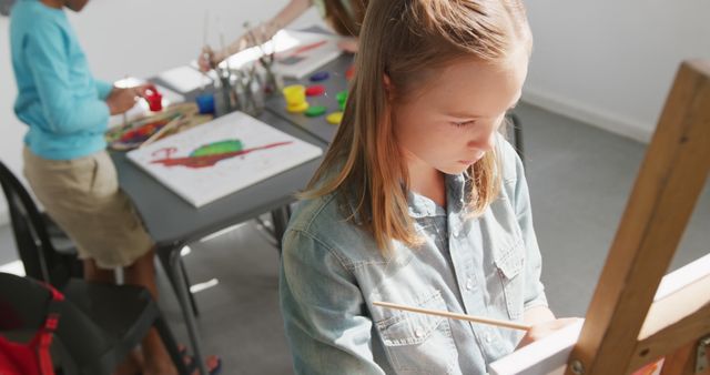 Focused Girl Painting at Easel in Art Classroom - Download Free Stock Images Pikwizard.com