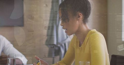 Woman presenting data and gesturing during collaborative meeting with analytics overlays