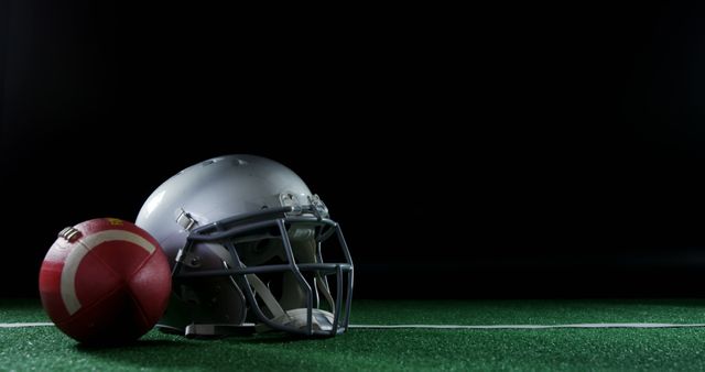 American Football Helmet and Ball on Turf with Dark Background - Download Free Stock Images Pikwizard.com