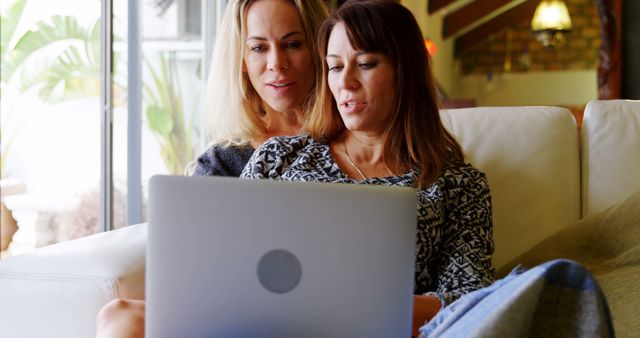 Two Women Using Laptop on Cozy Sofa at Home - Download Free Stock Images Pikwizard.com