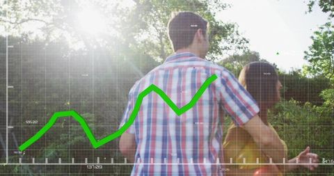 Couple standing embracing in sunlit park with green rising growth graph overlay