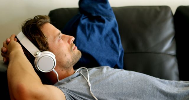Man Relaxing on Couch with Headphones Listening to Music - Download Free Stock Images Pikwizard.com