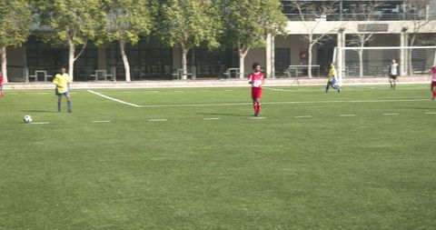 Youth Soccer Players Competing on School Field Focusing on Teamwork