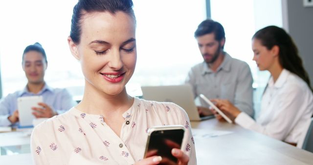 Young professional woman using smartphone in modern office workspace - Download Free Stock Images Pikwizard.com