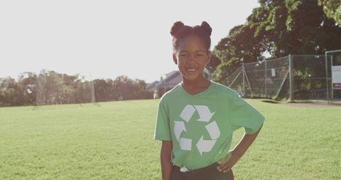 Smiling Child Promoting Recycling in Green Shirt Outdoors