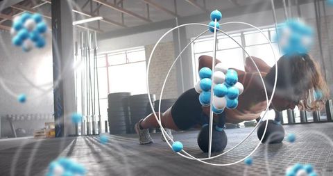 Female athlete holding kettlebells doing elevated plank with molecular overlay in gym