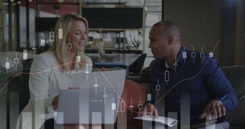 Business colleagues analyzing financial charts in modern office lounge