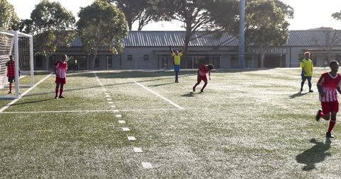 Youth soccer players practicing on sunny field during training