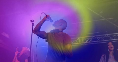 Energetic trio performing under vibrant spotlights