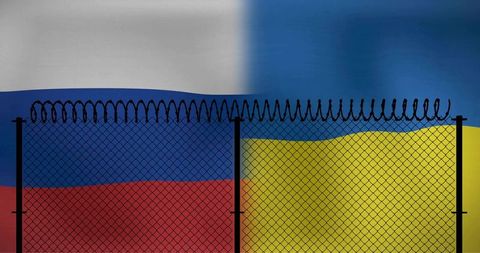 Dividing russia and ukraine flags with razor wire fence symbolizing border tension