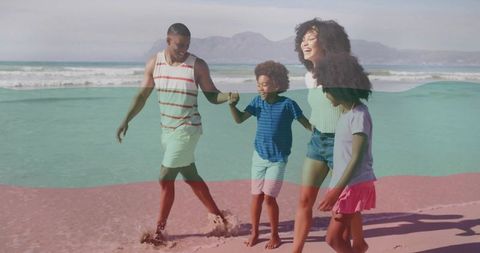 Family walking barefoot holding hands on sunlit beach with waves and footprints