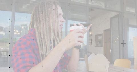 Young Man with Dreadlocks Talking on Smartphone in Cafe