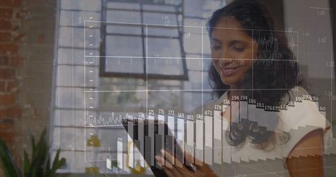 Businesswoman analyzing data on tablet with digital financial overlay