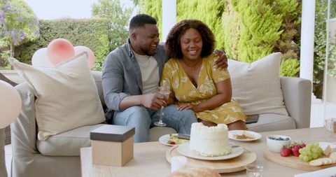 Happy Couple Celebrating with Cake and Wine on Patio