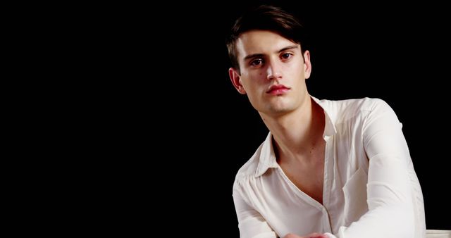 Confident Young Man Wearing White Shirt Against Black Background - Download Free Stock Images Pikwizard.com