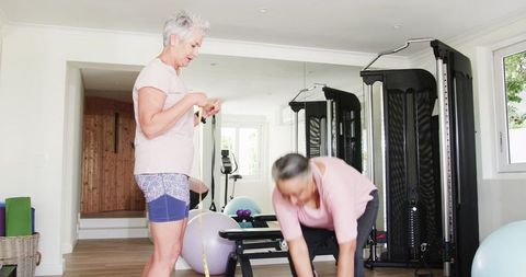 Senior Lesbian Couple Exercising Together in Home Gym