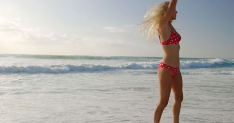 Joyful Woman in Red Polka Dot Bikini Enjoying Beach Under Sun - Download Free Stock Images Pikwizard.com