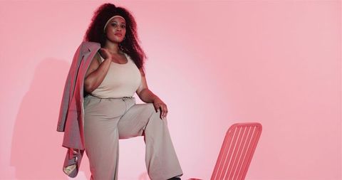 Fashionable African American Woman Posing Stylishly in Modern Studio Setting