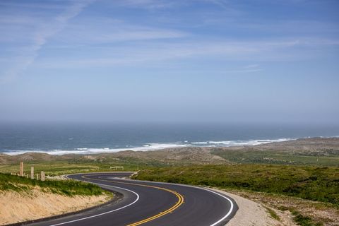 Scenic Coastal Road with Ocean View Under Clear Blue Sky
