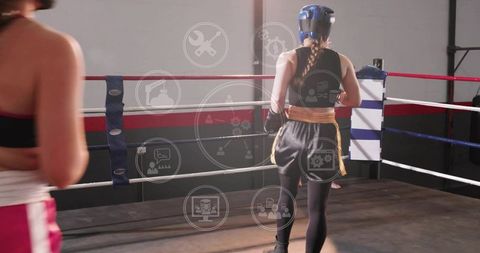 Female boxer sparring in ring wearing blue headgear and braided ponytail