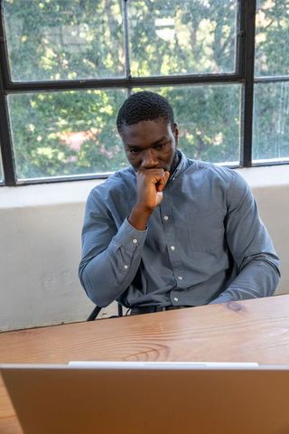 Focused professional man thinking at work desk