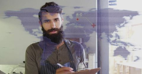 Bearded man in apron taking notes with overlay global map