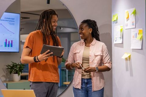 African american coworkers collaborating with tablet, analyzing charts, brainstorming