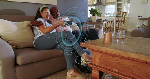 Couple lounging on sofa enjoying augmented reality gaming with holographic ui overlay