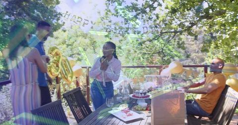 Woman Speaking at Outdoor 30th Birthday Party on Deck with Gold Balloons and Cupcakes