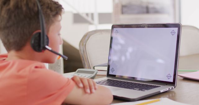 Child wearing headset studying online using laptop - Download Free Stock Images Pikwizard.com