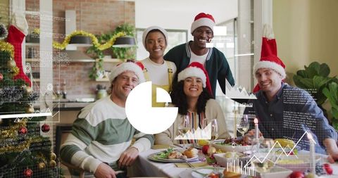 Multicultural friends celebrating holiday dinner wearing Santa hats festive table with charts