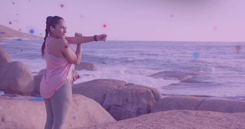 Young Woman Stretching on Scenic Oceanfront Rocks at Sunset