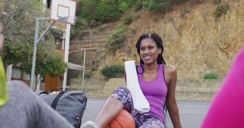 Smiling Female Athlete Relaxing Post Basketball Game Outdoor Court