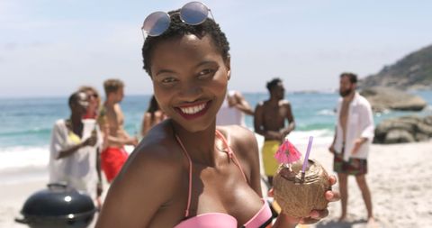 Woman Enjoying Beach Party Holding Coconut Drink