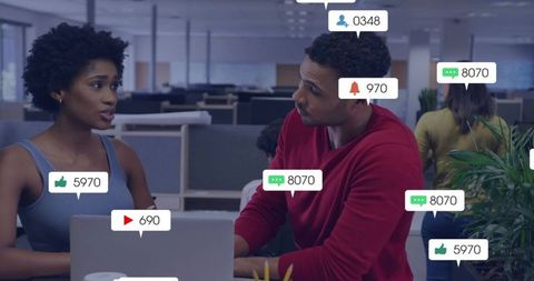 Discussing collaboration in modern open-plan office with social media notification icons