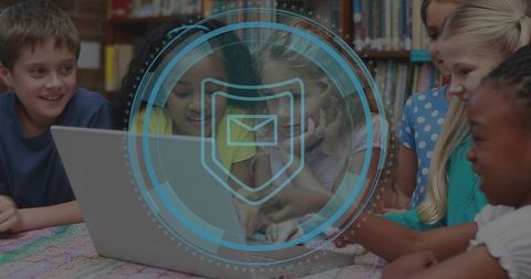 Kids collaborating on laptop in school library learning digital safety with shield overlay