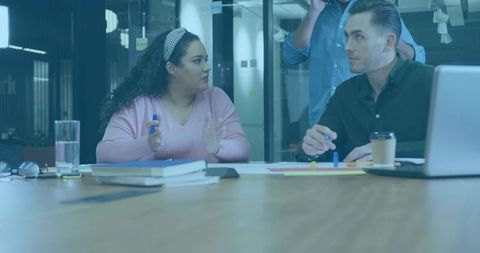 Team collaborating in modern office room, woman gesturing during brainstorming session