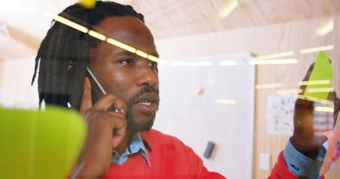 Focused Businessman Planning While on Phone Call in Office