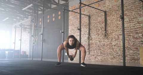 Female Athlete Performing Sumo Deadlift Exercise in Industrial Gym