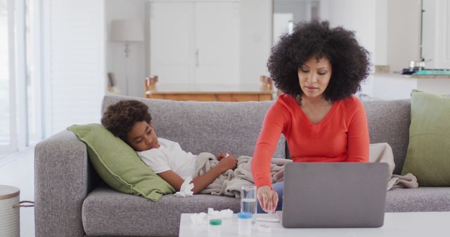 Mother Working on Laptop while Taking Care of Sick Son at Home - Download Free Stock Images Pikwizard.com