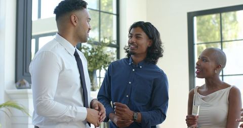 Diverse professionals networking and laughing in modern bright living room