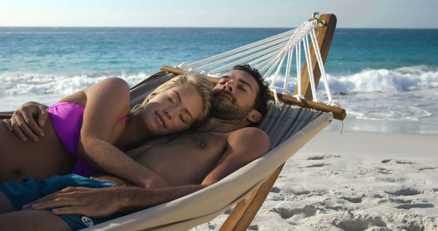 Couple lying in a hammock on a beach at sunset, enjoying a serene and romantic moment. Perfect for travel brochures, vacation advertisements, wellness blogs, and lifestyle promotions.