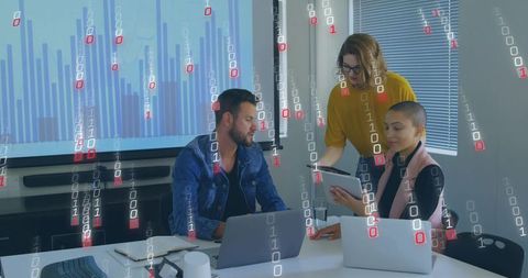 Team collaborating on data analytics dashboard with laptops and tablet in modern office
